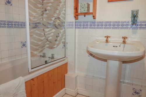 特鲁罗The Granary的浴室配有水槽、淋浴和浴缸。