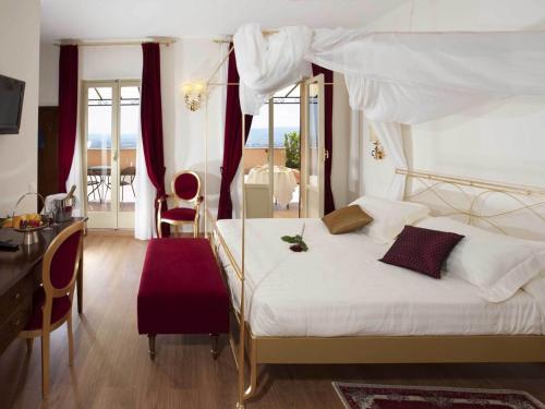 阿西西吉欧托温泉酒店的一间卧室配有一张带天蓬的白色床