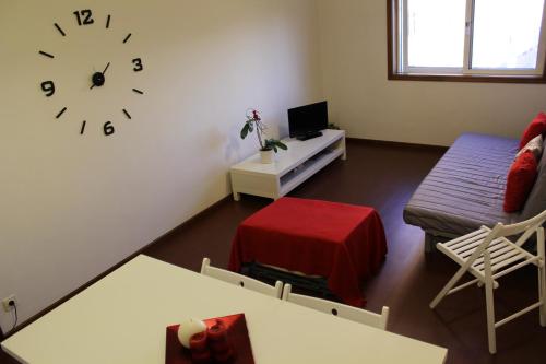 加亚新城House4U Vila Nova的客厅配有沙发和墙上的时钟