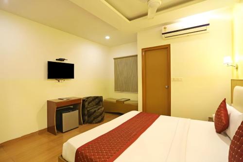 新德里Hotel IVY Near IGI Delhi Airport的配有一张床和一台平面电视的酒店客房