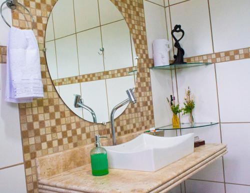 圣若昂-巴蒂斯塔-杜格罗里亚Pousada Encantos do Glória的一间带水槽和镜子的浴室