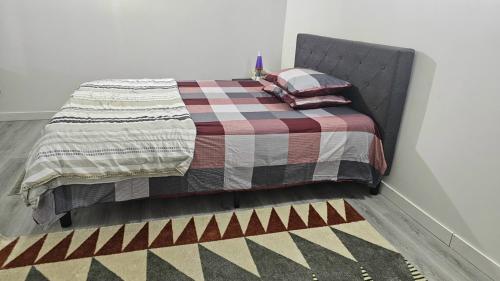 埃德蒙顿Charming city hideaway: modern comfort的一张带 ⁇ 子毯子和枕头的床