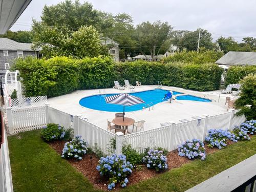 埃德加敦Edgartown Commons Vacation Apartments的花团锦簇的游泳池周围的白色围栏
