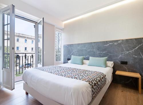 圣地亚哥－德孔波斯特拉PR 25 德胡里奥酒店的一间卧室设有一张大床和一个大窗户