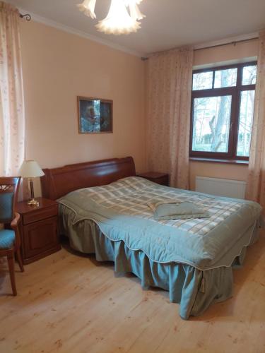 拉加希姆斯Saulesdarzs的卧室配有床、椅子和窗户。