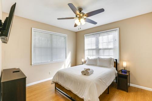 班布里奇Bainbridge Home with Cove and Lake Seminole Access!的一间卧室配有一张带吊扇的床和2扇窗户。