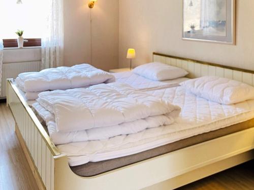 SvanesundHoliday home Svanesund VI的一张白色大床,配有白色床单和枕头