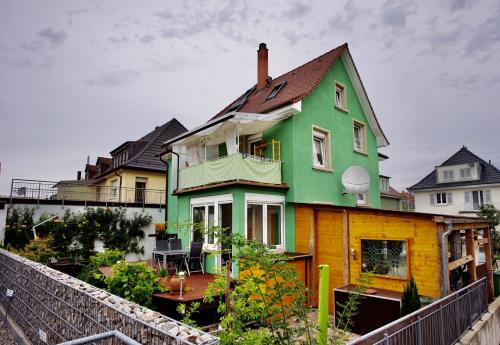 加格瑙Ferienwohnung Ambiente的绿色和黄色的房屋,设有围栏