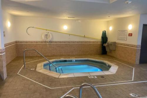 特洛伊Troy Inn & Suites的一个带按摩浴缸的大房间,内设网球场