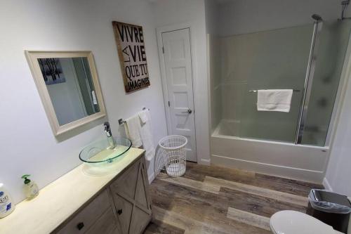 圣弗朗索瓦小河Cottage Quebec - La Nepheline的浴室配有水槽、淋浴和浴缸。