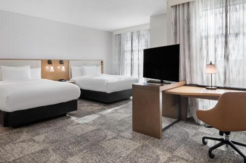 查茨沃斯Residence Inn by Marriott Chatsworth的酒店客房设有两张床和一张书桌及电视