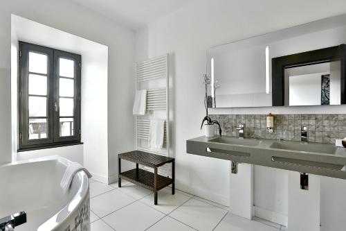 于泽什久瓦夜德莫贝可酒店的一间带水槽、浴缸和镜子的浴室