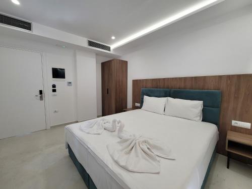卡萨米尔Prestige Hotel的卧室配有带毛巾的大型白色床