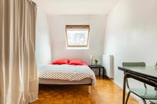 欧奈索斯博伊斯Chbre 2P + navette CDG的一间卧室配有一张带红色枕头的床