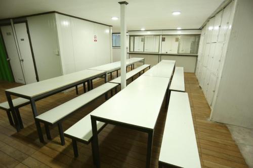 塔尔卡hostal ibiza的一间更衣室里一排白长椅