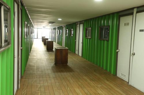塔尔卡hostal ibiza的建筑中带绿色墙壁和长凳的走廊