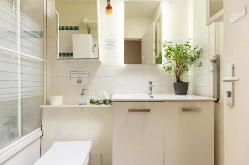 欧奈索斯博伊斯Chbre 2P + navette CDG的浴室设有白色橱柜、水槽和盆栽植物