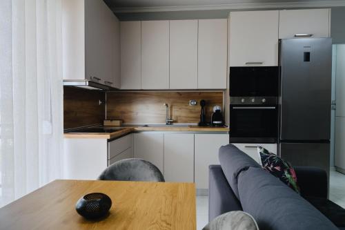 亚历山德鲁波利斯Faros Flat的厨房配有沙发、桌子和冰箱。