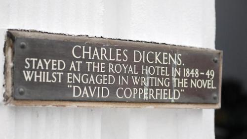 大雅茅斯Royal Hotel Great Yarmouth的白色的墙上贴着一个标志