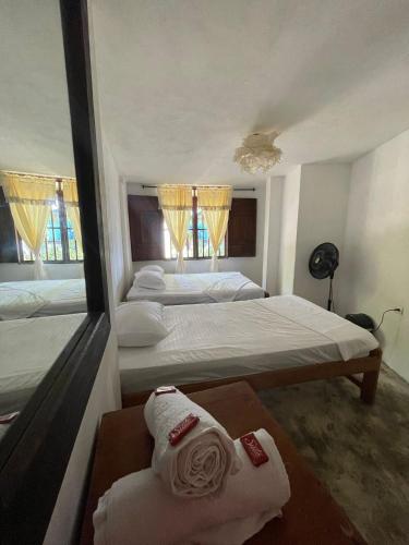 卡普兰干Hospedaje Kairos Capurgana的一间卧室配有两张床和一张桌子上的毛巾