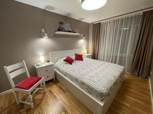 卢扎Piektais stāvs / 5th floor的卧室配有床、椅子和窗户。