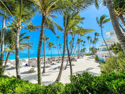 蓬塔卡纳DUCASSI SUITE Sol Karibe SUITES STUDIOS TROPICANA Rooftop POOL WiFi Beach & SPA的棕榈树海滩和海洋