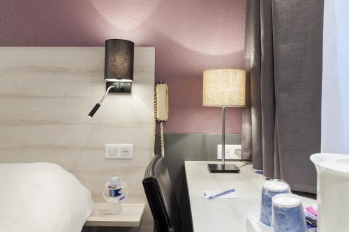 阿斯克新城东里尔基里亚德酒店 - 阿斯克新城的酒店客房,配有一张床和一张书桌上的电话