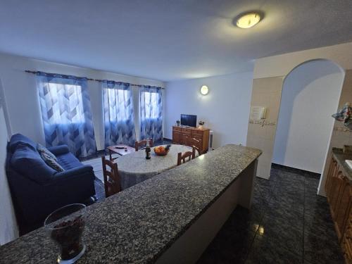 圣伊西德罗Apartamento Mendoza I - San Isidro的厨房以及带沙发和桌子的客厅。