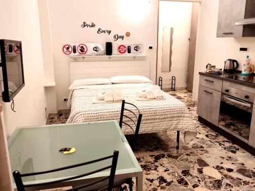 都灵Locazione Turistica Casa Gardenia的厨房配有床、桌子和毛巾