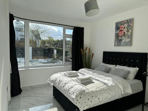 巴尔内特Luxurious & Elegant 6-Bed House的一间卧室设有一张床和一个大窗户