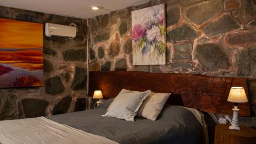 RacoLa Pedra Hotel Boutique, Raco的一间卧室设有石墙和床