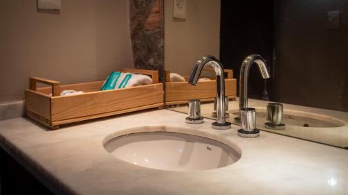 RacoLa Pedra Hotel Boutique, Raco的浴室水槽设有2个水龙头和镜子