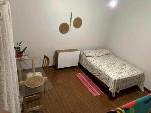 阿拉拉夸拉Hostel Namastê的一间小卧室,配有一张床和一张桌子