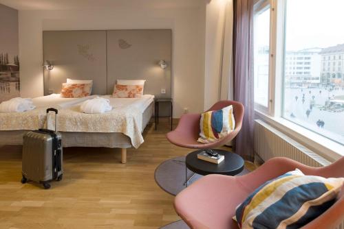 马尔默斯堪迪克圣约根酒店的酒店客房,配有两张床和两把椅子