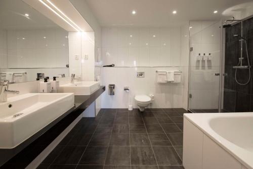 马尔默斯堪迪克圣约根酒店的浴室配有2个盥洗盆、卫生间和淋浴。
