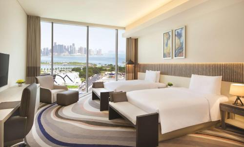 多哈多哈老城希尔顿逸林酒店的酒店客房设有两张床和大窗户。