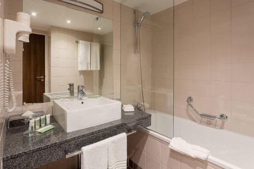 图卢兹万豪图卢兹机场度假酒店的浴室配有白色水槽和淋浴。