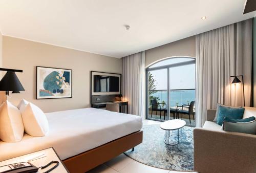 圣保罗湾城DoubleTree by Hilton Malta的酒店客房,配有床和沙发