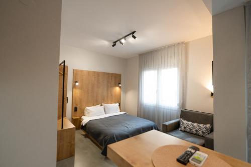 科莫蒂尼THEMIS URBAN STAY的酒店客房配有一张床铺和一张桌子。