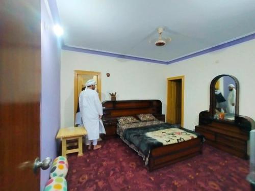 LamniānSharian Guest House的一个人站在卧室里,躺在床上