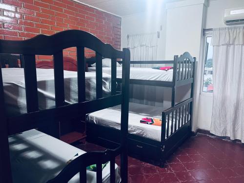 拉塞瓦Los Guacamayos La Ceiba的带两张双层床和砖墙的客房