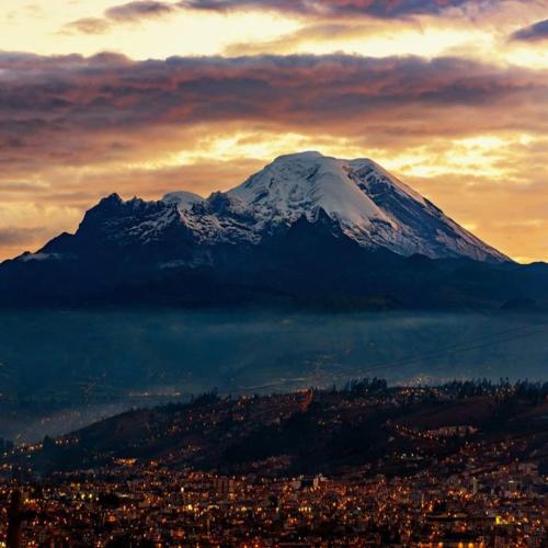 里奥班巴Hospedaje Riobamba的城市前的雪覆盖的山