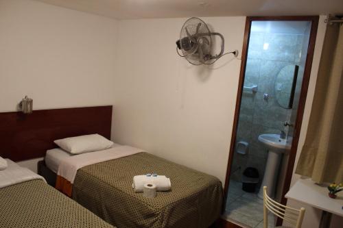 利马COPACABANA的一间带两张床和淋浴的小卧室
