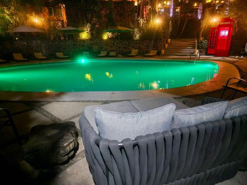 库埃纳瓦卡Hotel Grand Vista Cuernavaca的游泳池前的沙发,晚上