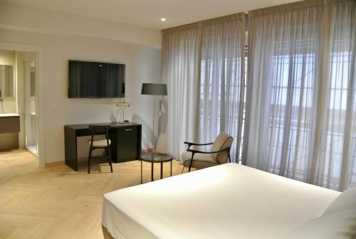 佛罗伦萨The Old Palace- Luxury Suites Signoria的一间卧室配有一张床、一张桌子和一张桌子