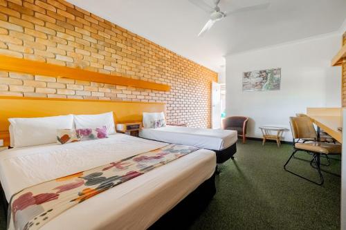 巴卡尔丁Landsborough Lodge Motel的酒店客房带两张床和砖墙