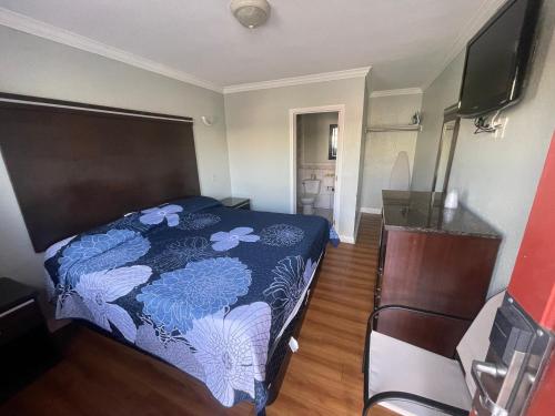 洛杉矶La Cienega Inn Motel的一间卧室配有一张带蓝色和白色床单的床。
