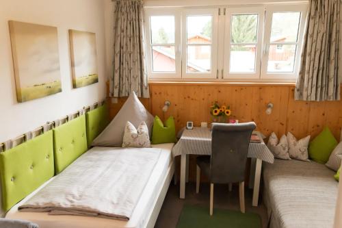 基姆湖畔贝尔瑙Gästehaus Sattlerhof的客房设有两张床、一张桌子和一扇窗户。