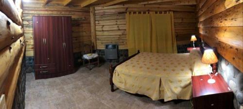 佩休尼亚镇帕拉伊索宾馆的小木屋内一间卧室,配有一张床
