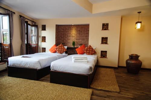 巴克塔普尔塔古晨精品酒店的一间卧室设有两张床和砖墙